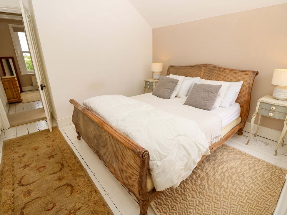 A bedroom with a bed and nightstand at Fern Cottage in Bembridge