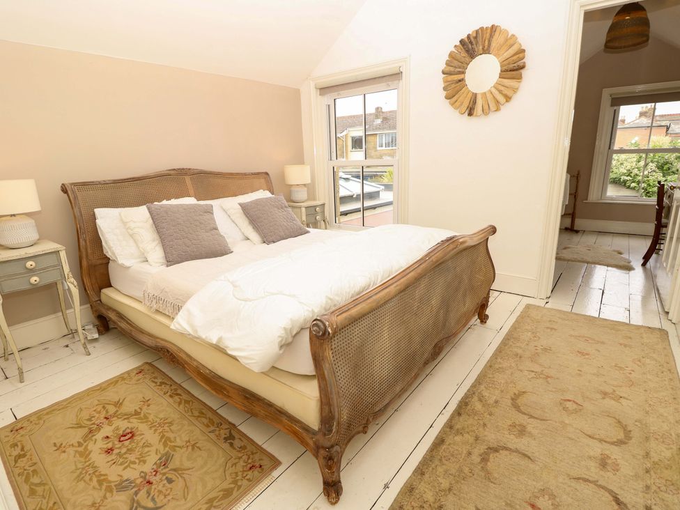 A bedroom with a bed and nightstand at Fern Cottage in Bembridge