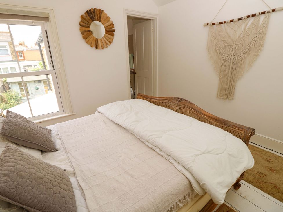 A bedroom with a bed and window at Fern Cottage in Bembridge