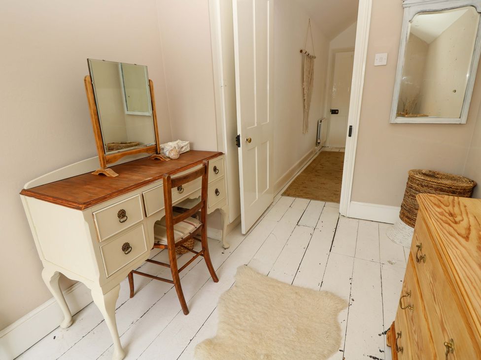 A hallway with a vanity desk and mirror at Fern Cottage in Bembridge