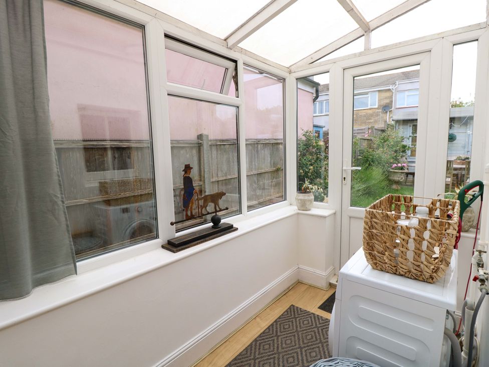 A conservatory with a view of the garden at Fern Cottage in Bembridge
