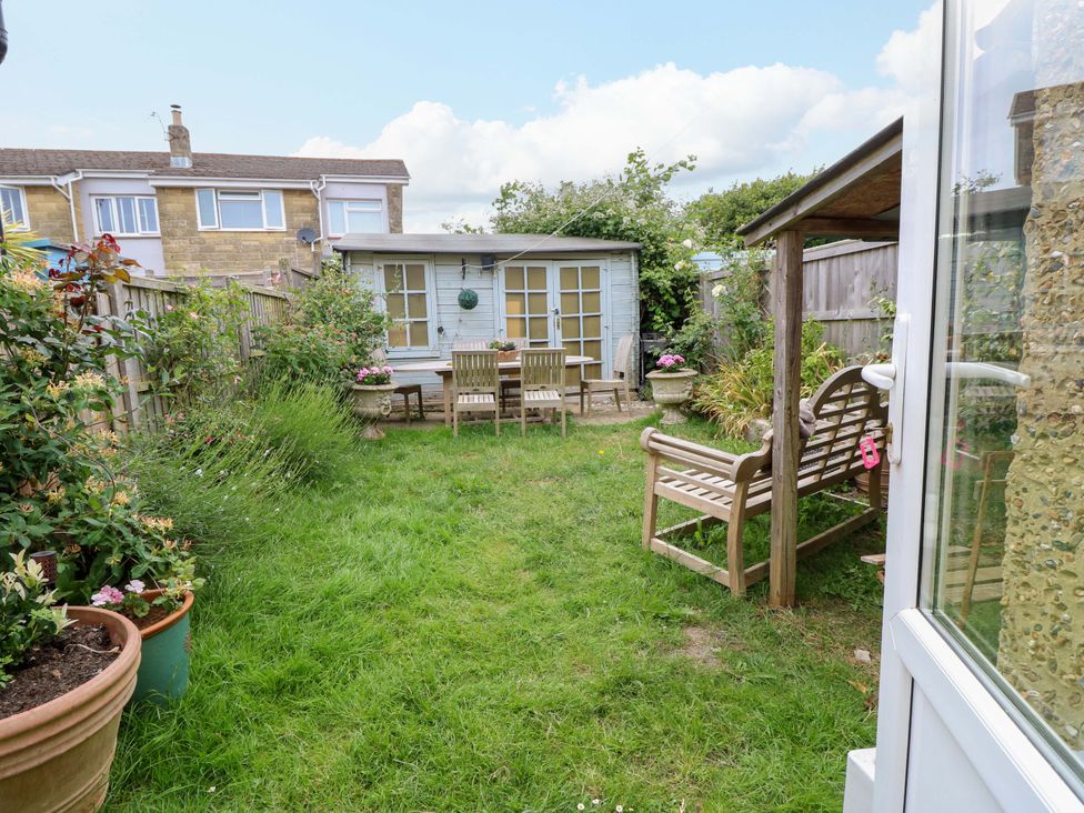 A garden with a shed and seating area at Fern Cottage in Bembridge