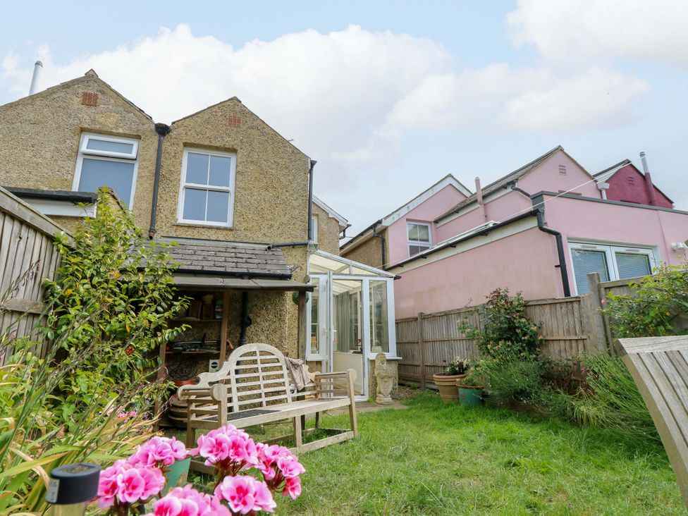 A garden with a bench and plants at Fern Cottage in Bembridge