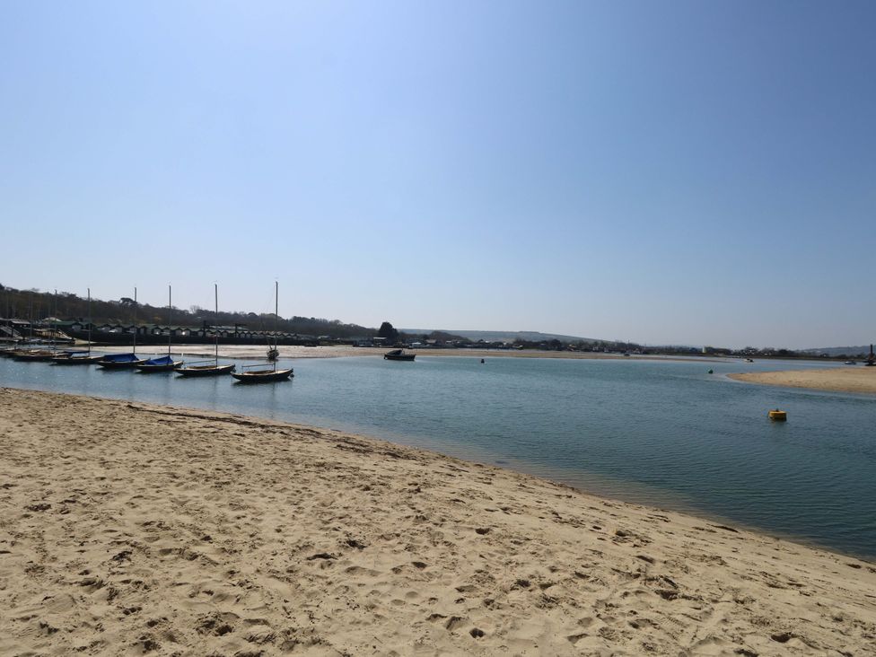 A beach scene with boats and water at Fern Cottage in Bembridge