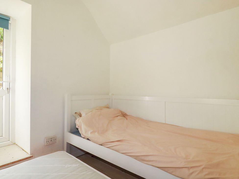 A bedroom with a bed near a window at 18 Tregea Terrace in Portreath