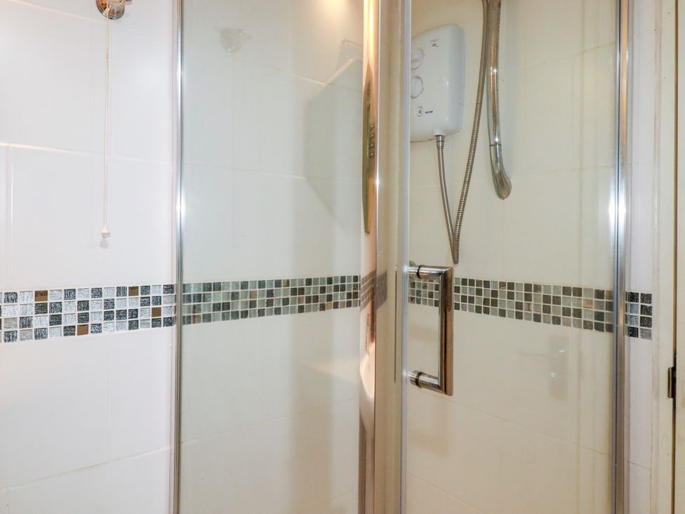 A shower with controls and tiles at 18 Tregea Terrace in Portreath