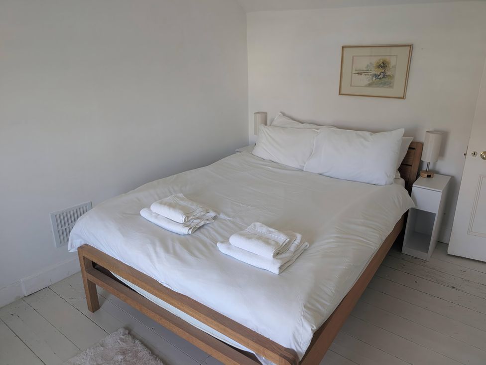 A bedroom with a bed and bedside tables at Fairsands in Portreath