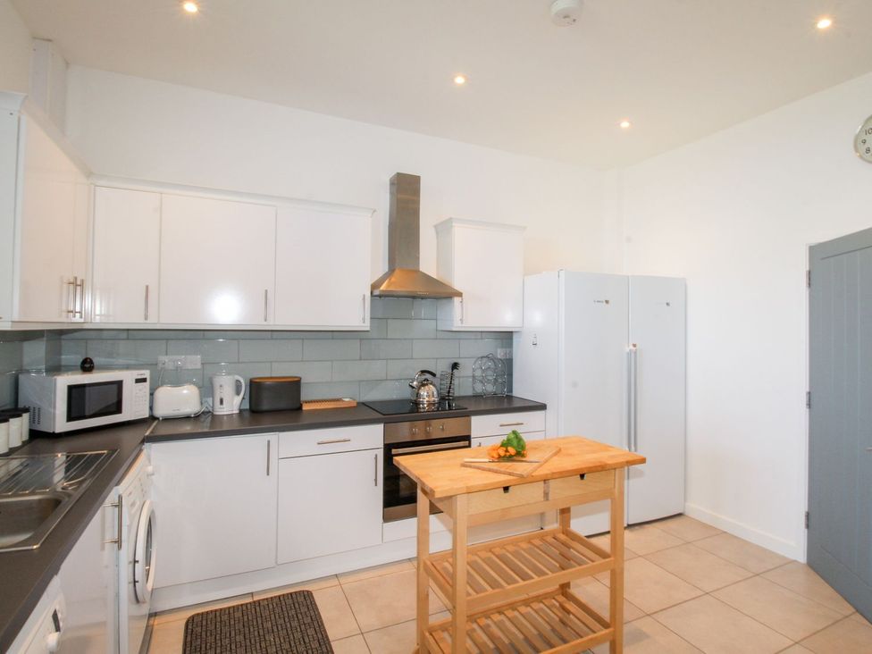 A kitchen with cabinets, appliances, and a kitchen island at Portland View in Portland Bill