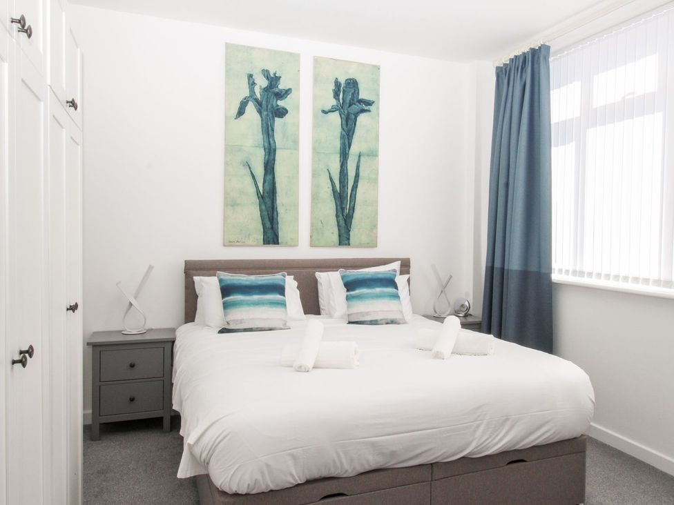 A bedroom with a bed and wall art at Portland View in Portland Bill