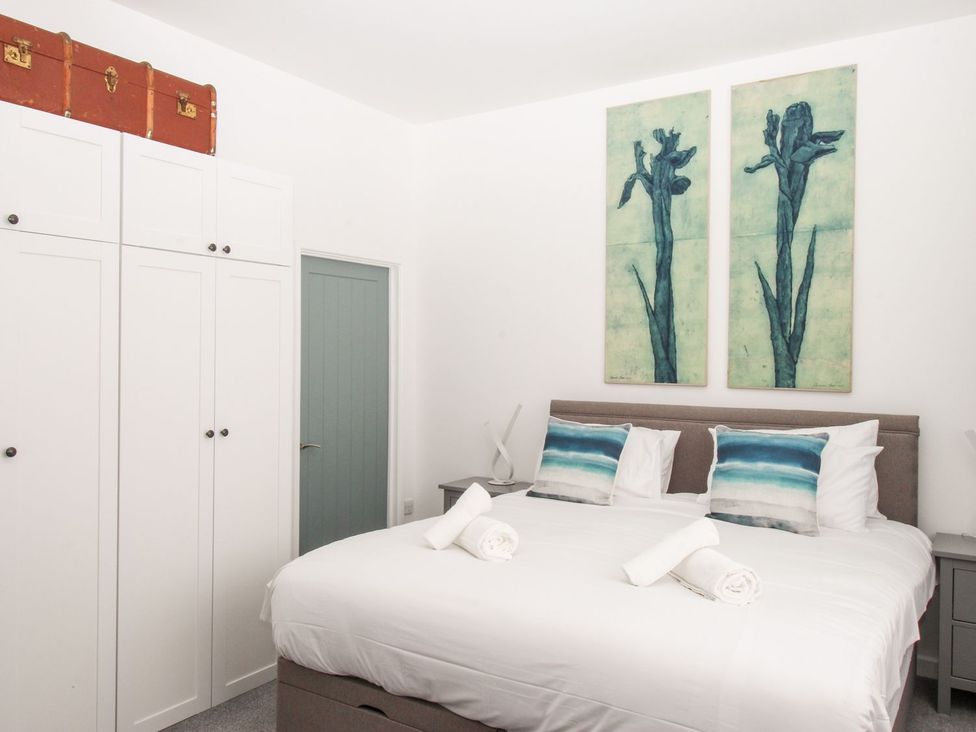 A bedroom with a bed and wardrobe at Portland View in Portland Bill