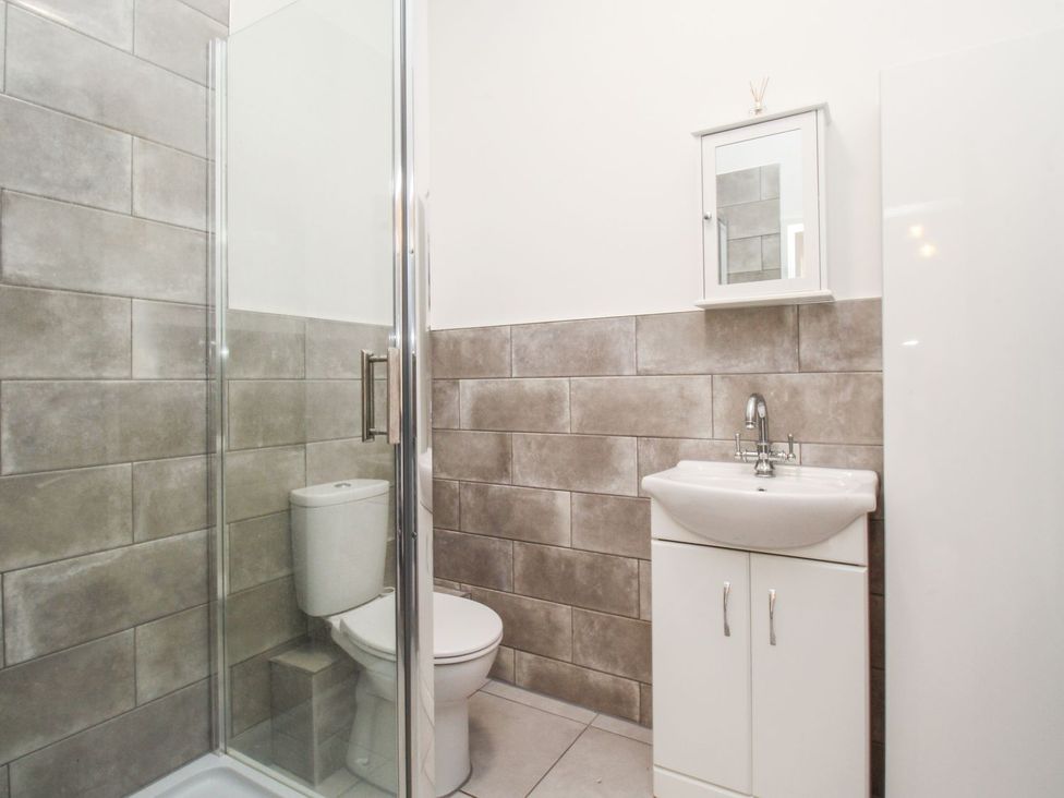 A bathroom with a shower, toilet, and sink at Portland View in Portland Bill