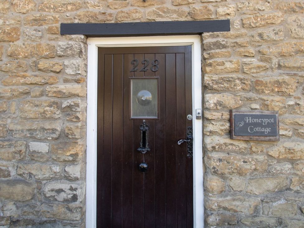 A front door with stone wall at Honeypot Cottage in Weymouth