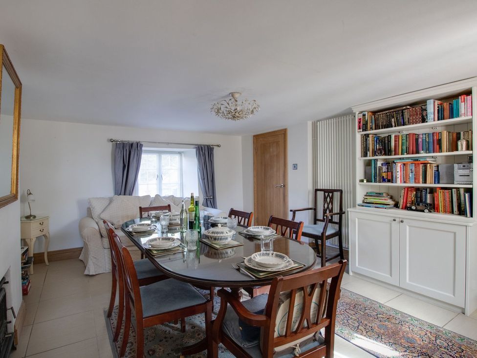 A dining room with a table set for a meal at Honeypot Cottage in Weymouth