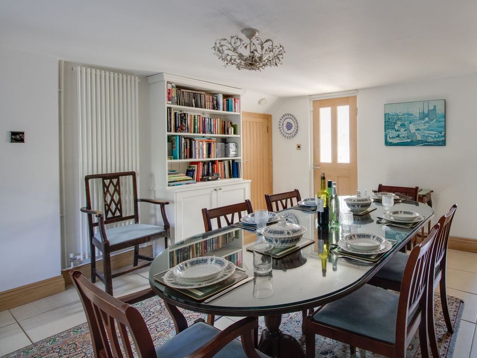 A dining room with a table set for dinner at Honeypot Cottage in Weymouth