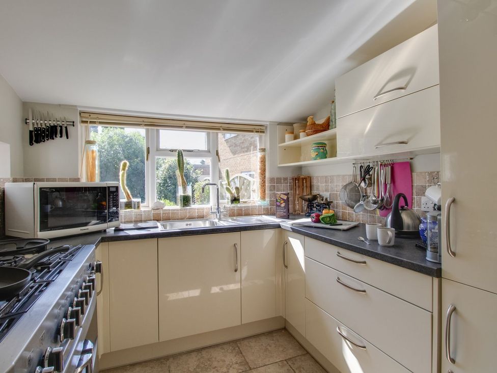 A kitchen with a sink and microwave at Honeypot Cottage in Weymouth