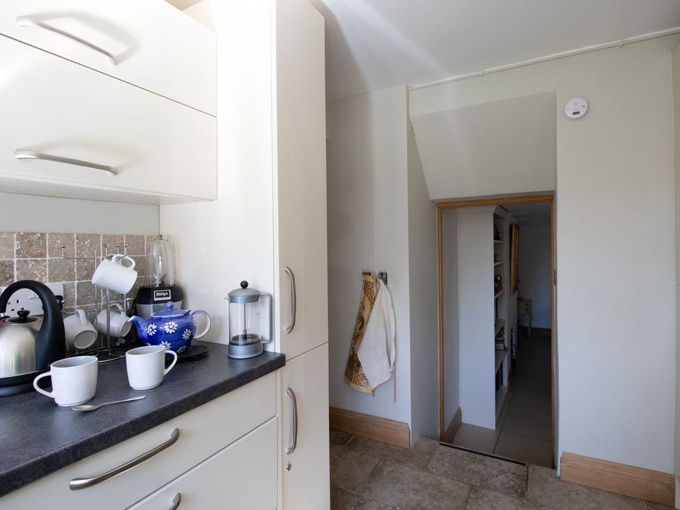 A kitchen with a kettle and blender on the counter at Honeypot Cottage in Weymouth