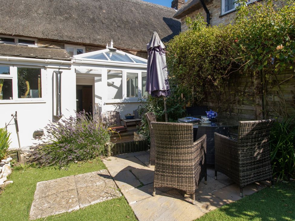 A garden with a table and chairs at Honeypot Cottage in Weymouth