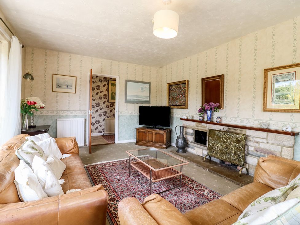 A living room with a sofa, coffee table, and television at The Lodge 