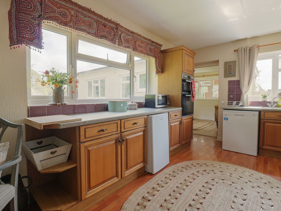 A kitchen with cabinets, microwave, sink, and dishwasher at The Lodge 