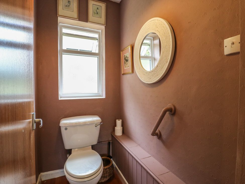 A bathroom with a toilet and mirror at The Lodge in 
