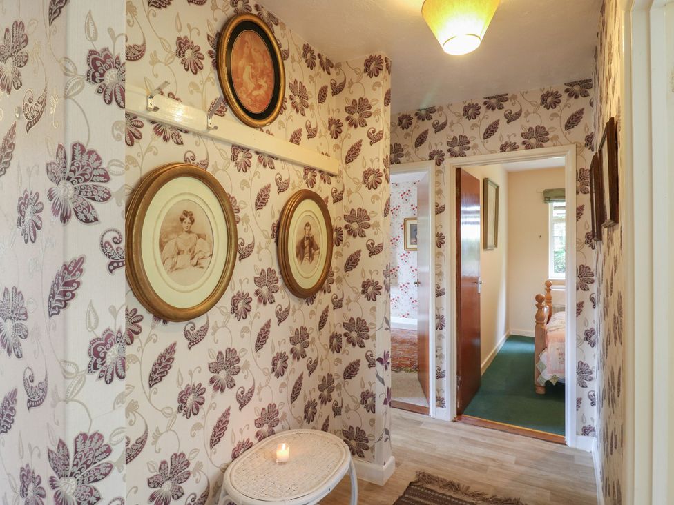 A hallway with framed pictures on the wall at The Lodge 