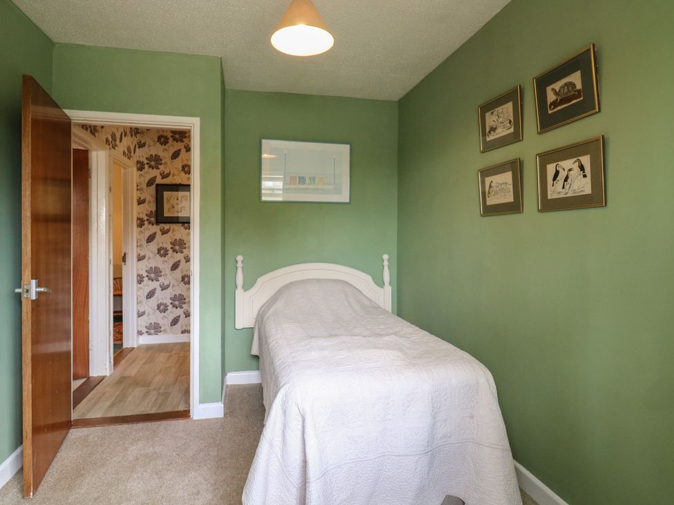 A bedroom with a single bed and wall art at The Lodge 