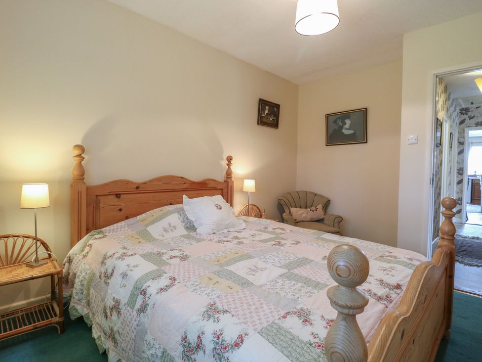 A bedroom with a bed and armchair at The Lodge 