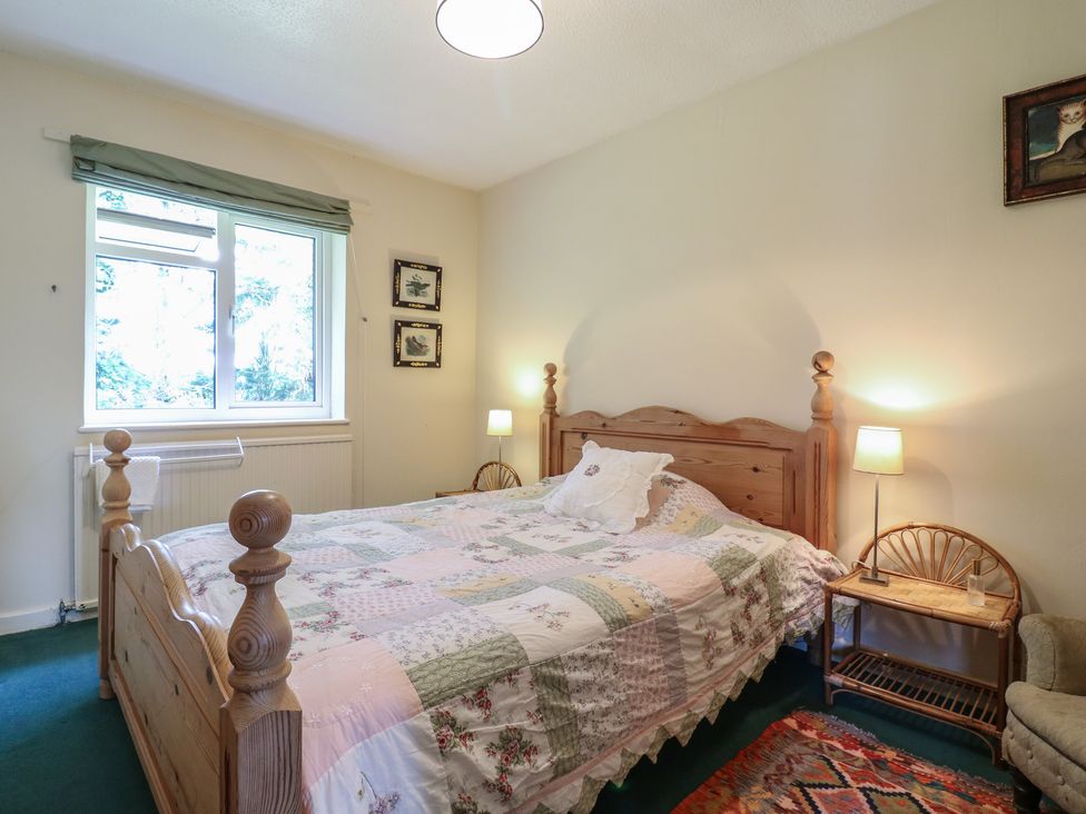 A bedroom with a bed and lamp at The Lodge 