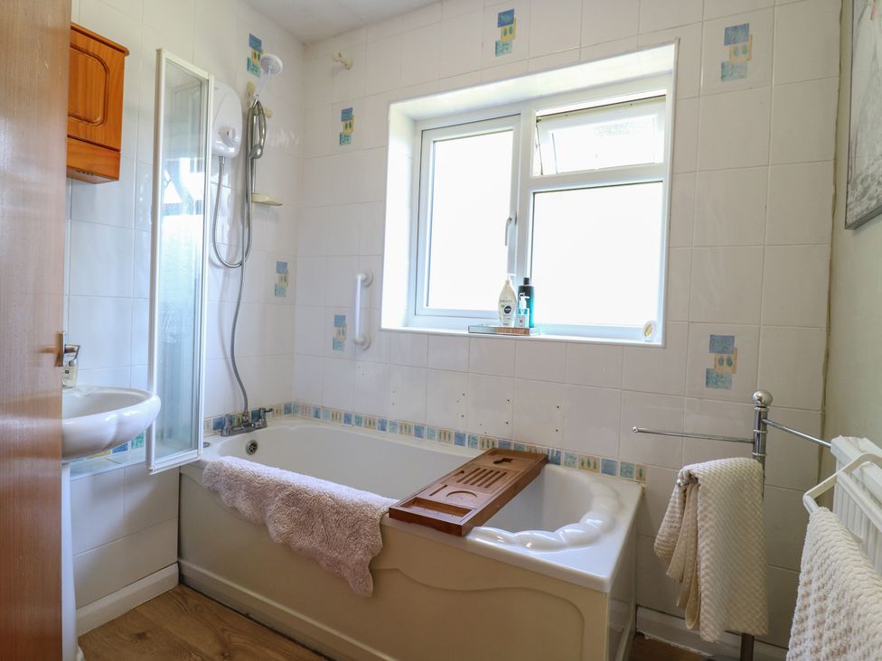 A bathroom with bathtub, shower, and sink at The Lodge in 