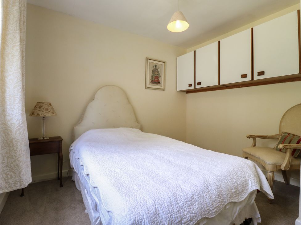 A bedroom with a bed and a lamp on a table at The Lodge in 