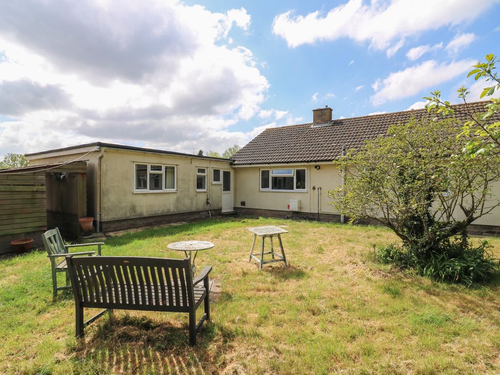 A house with a garden area featuring chairs and a table at The Lodge 