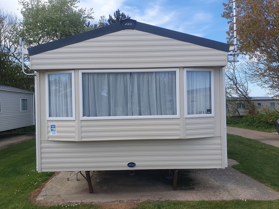 A caravan with windows and curtains at Caravan 325 Lowestoft