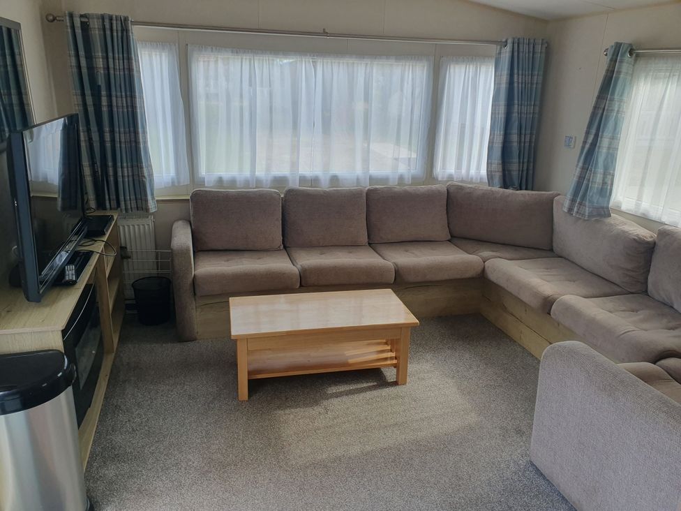 A living room with a sofa and coffee table at Caravan 325 in Lowestoft
