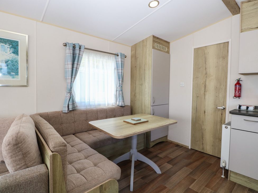 A dining area with a couch and table at Caravan 325 in Corton