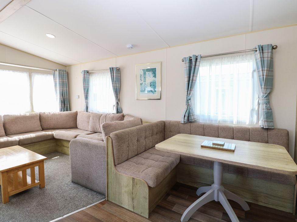A living room with a sofa and dining table at Caravan 325 in Corton