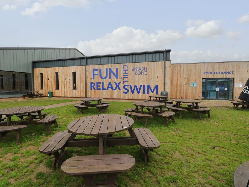 An outdoor area with tables and a building entrance at Caravan 325 in Corton