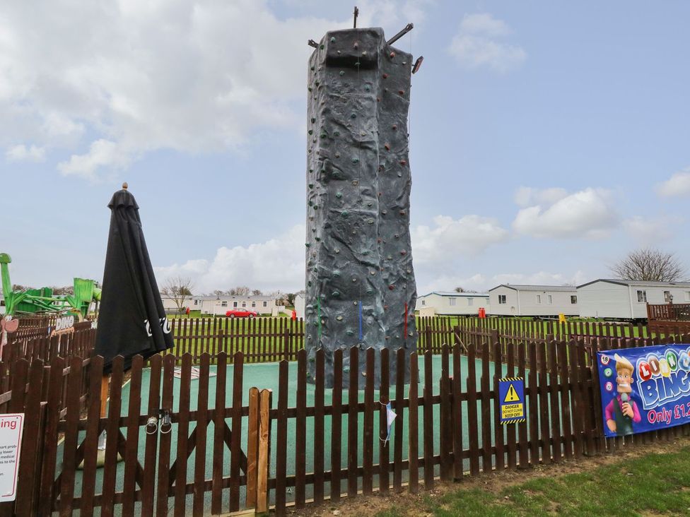An outdoor rock climbing wall with a protective area at Caravan 325 in Corton