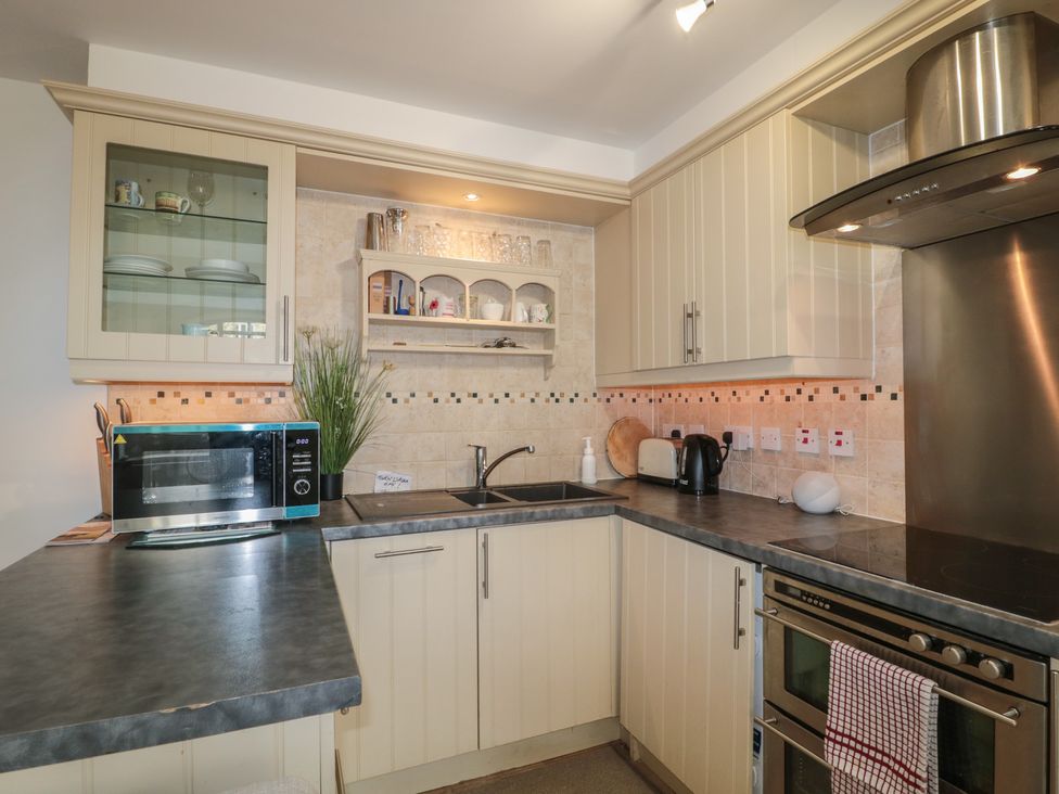 A kitchen with a microwave, sink, kettle, and toaster at Longfords Mill near Nailsworth