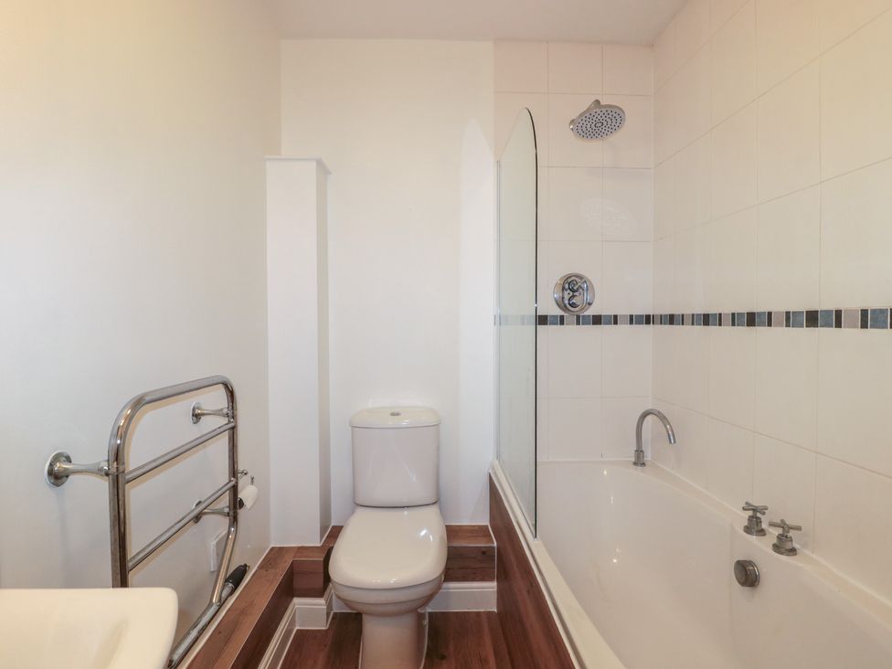 A bathroom with a bathtub, toilet, and shower at Longfords Mill near Nailsworth