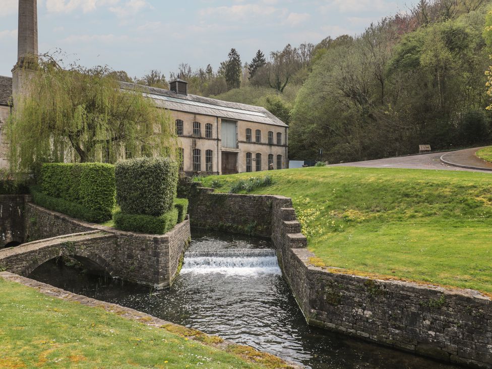 A building beside a stream and bridge at Longfords Mill near Nailsworth