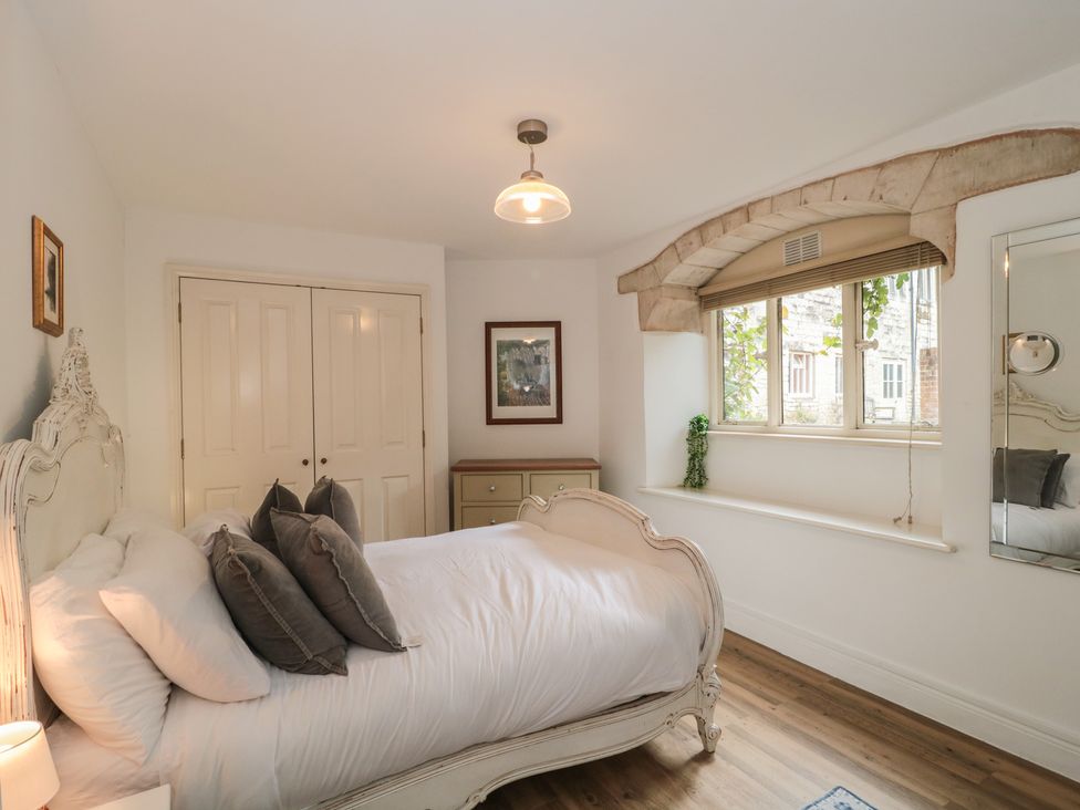 A bedroom with a bed and a window at Longfords Mill, Minchinhampton