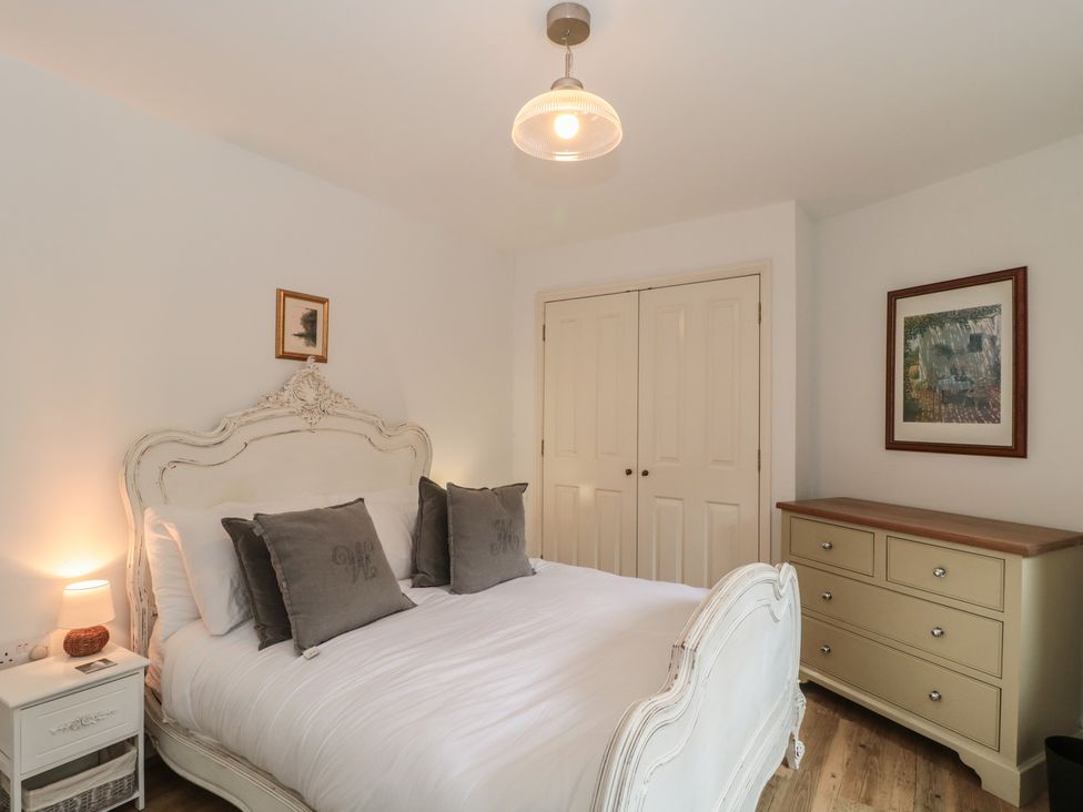 A bedroom with a bed and nightstand at Longfords Mill, Minchinhampton