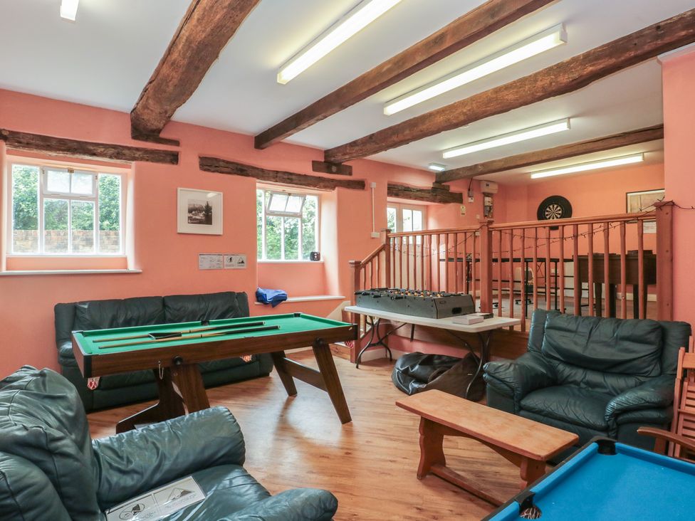 A recreation room with a pool table and foosball table at Longfords Mill, Minchinhampton in Nailsworth