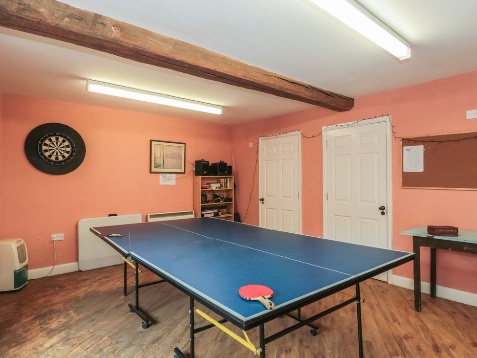A recreational room with a ping pong table and dartboard at Longfords Mill, Minchinhampton
