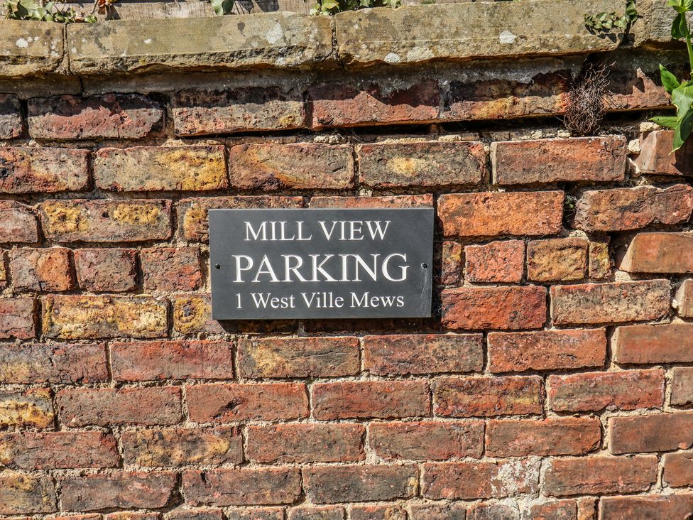 A parking sign on a brick wall at 1 West Ville Mews in York