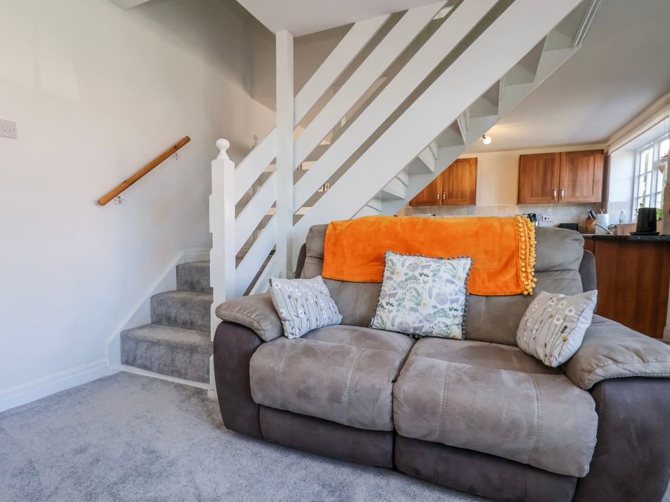 A living room with a sofa and staircase at 1 West Ville Mews in York