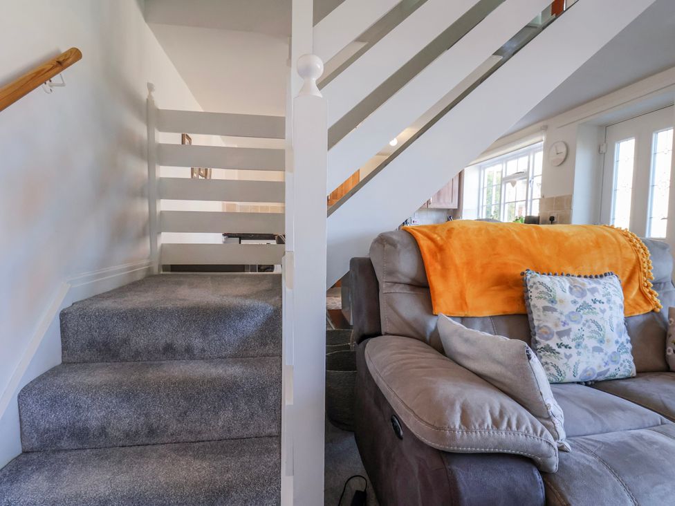 A living room with a sofa and staircase at 1 West Ville Mews York