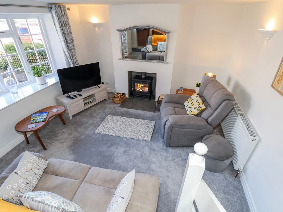 A living room with a fireplace and television at 1 West Ville Mews York