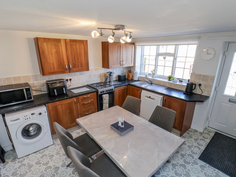 A kitchen with wooden cabinets and appliances at 1 West Ville Mews, York