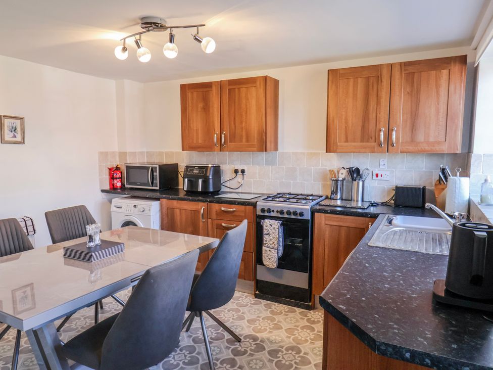 A kitchen with cabinets, a table and chairs, and appliances at 1 West Ville Mews York